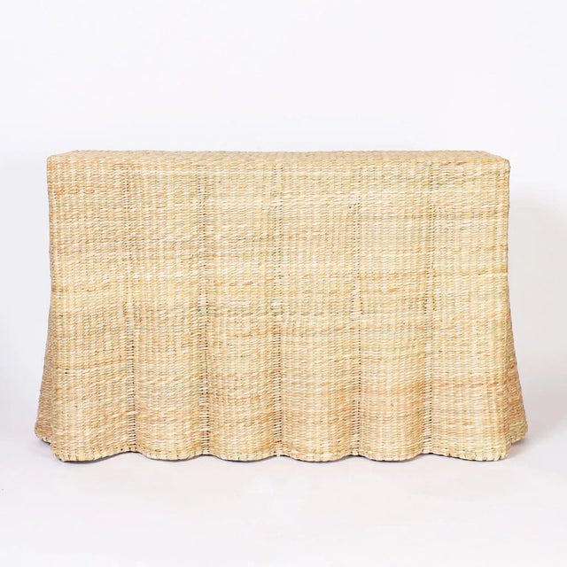 The Fernanda, a pair of chic wicker drapery ghost consoles crafted with woven reed over a sturdy metal frame with the...