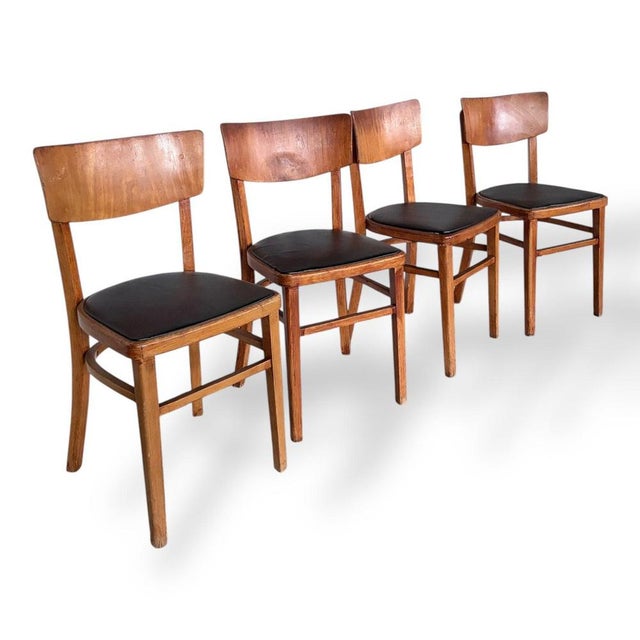 A stylish set of four mid-century dining chairs crafted from solid beech, featuring gently curved backrests and sleek...