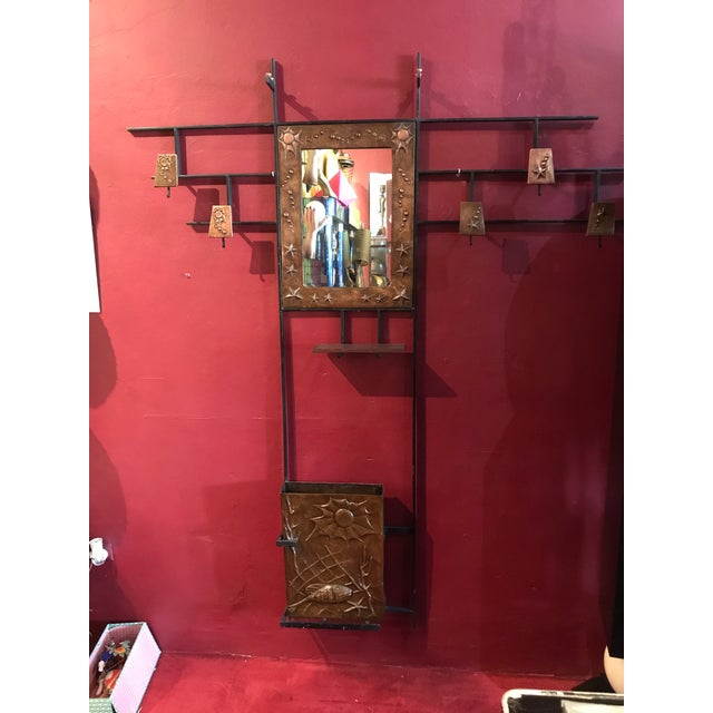 Hall tree in iron it should have glass shelve on top. It has a mirror sea theme motif on the reliefs of the copper part....