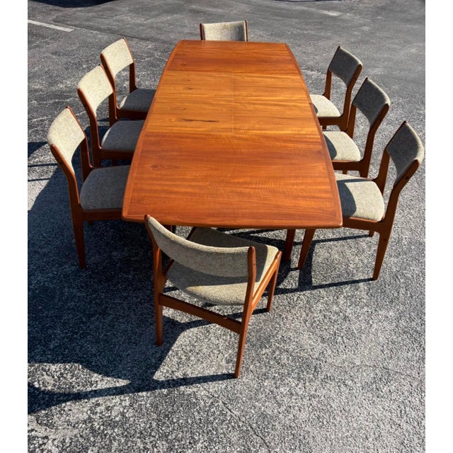 An incredible, classic Danish teak dining set. The table is constructed brilliantly with two recessed butterfly leaves...