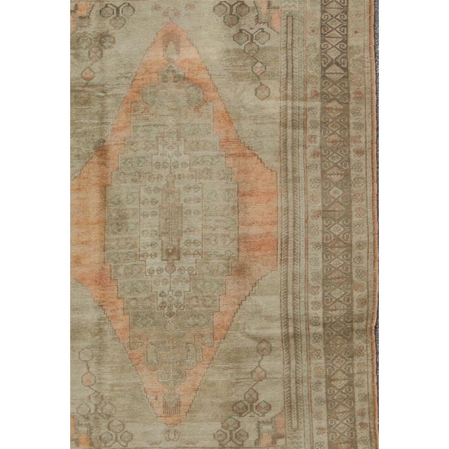 Measures: 6'0 x 9'9 1940s taupe vintage Oushak rug from Turkey with light salmon / coral medallion. Keivan Woven Arts /...