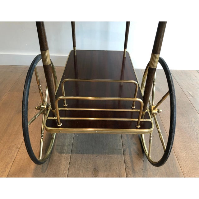 This neoclassical style bar cart is made of mahogany and brass. This is a French work in the style of famous designer...