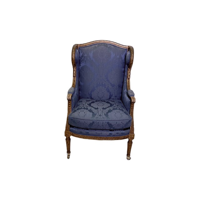 Gorgeous 19th-century French giltwood wingback chair with blue silk damask upholstery. On casters. A lovely addition to...