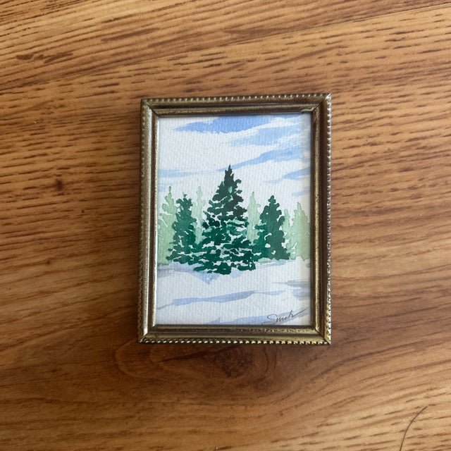 A quiet grove of evergreen trees stands tall beneath a soft winter sky in this tranquil watercolor. Painted in crisp...