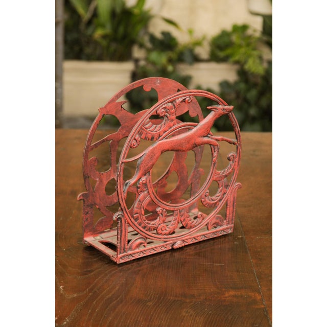 An English red painted metal magazine rack from the first half of the 20th century, with greyhound or whippet dogs in...