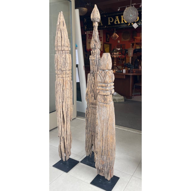 This striking trio of antique architectural sculptures showcases the weathered beauty of Thai That Mai (wooden stupas)...