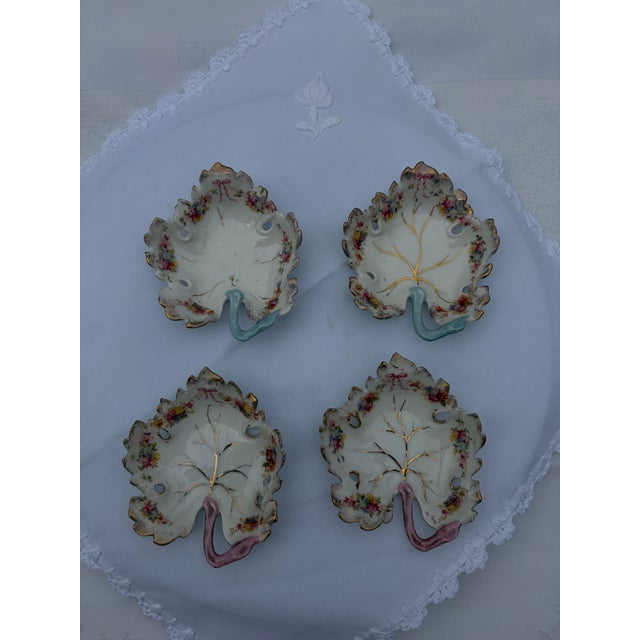A charming set of four vintage hand-painted fine porcelain leaf-shaped trinket, nut, or individual candy dishes. Styled...