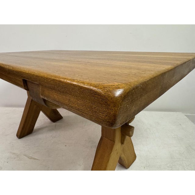 A solid oak dining table by De Puydt, Belgium, mid-20th century. The table features a thick rectangular top with softly...