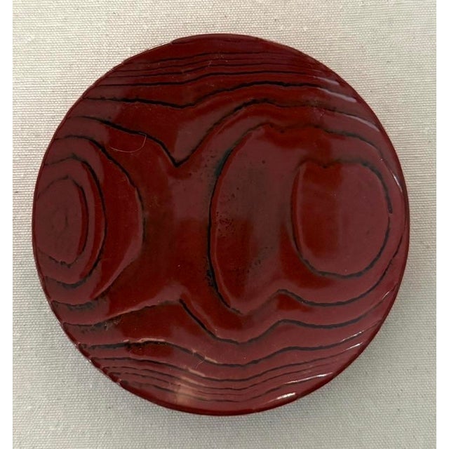 Deep red laquered catchall. Faux bois detailing to top and bottom.
