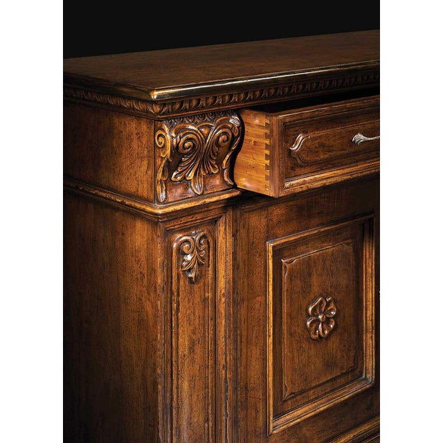 Handcrafted in Italy from solid walnut, this sideboard features a hand-carved design with raised panel doors, carved...