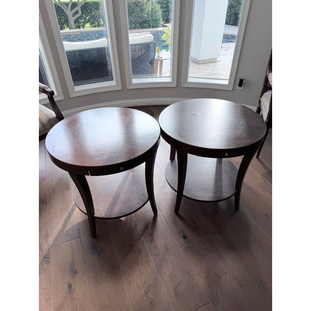 A beautifully matched pair of dark mahogany circular side tables in the Chippendale tradition. Each features a graceful...
