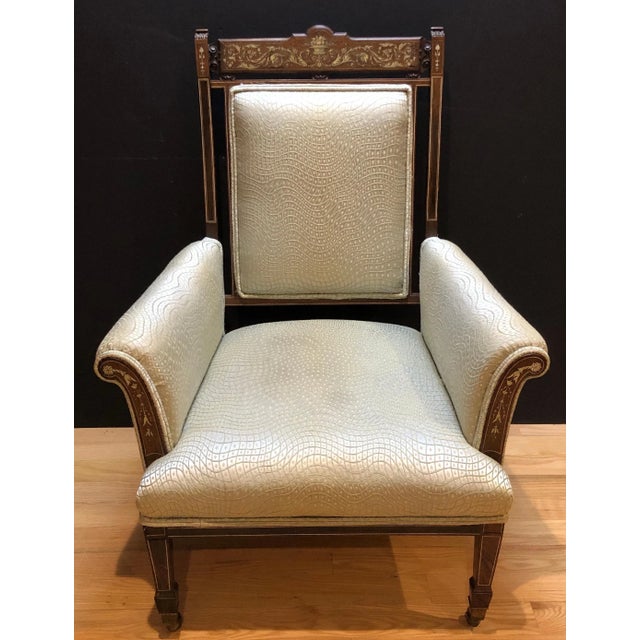 A fine late 19th century English rosewood armchair, richly decorated with engraved classical inlay, circa 1875–1890. The...