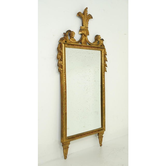 Neoclassical style Italian made wall mirror made of gilded gold wood. The mirror features fluer del lis and acanthus...