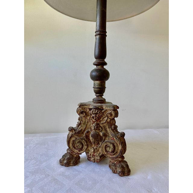 18th century one candle stick in Italian wood The base carved with volutes rests on three lion's feet. A face sculpts on...