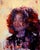 The painting "Ruby" features a softly blended portrait that captures a figure with curly hair, enveloped in rich, vibrant...