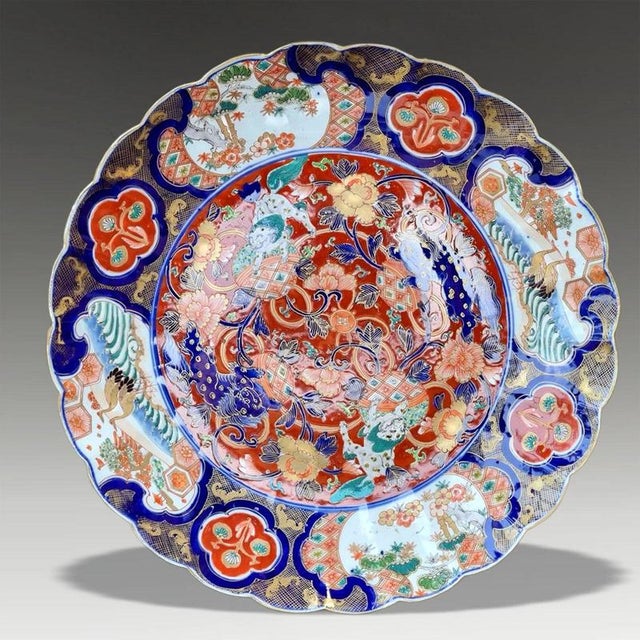 A richly decorated Japanese Arita porcelain charger dating to the Meiji period and distinguished by its elegant scalloped...