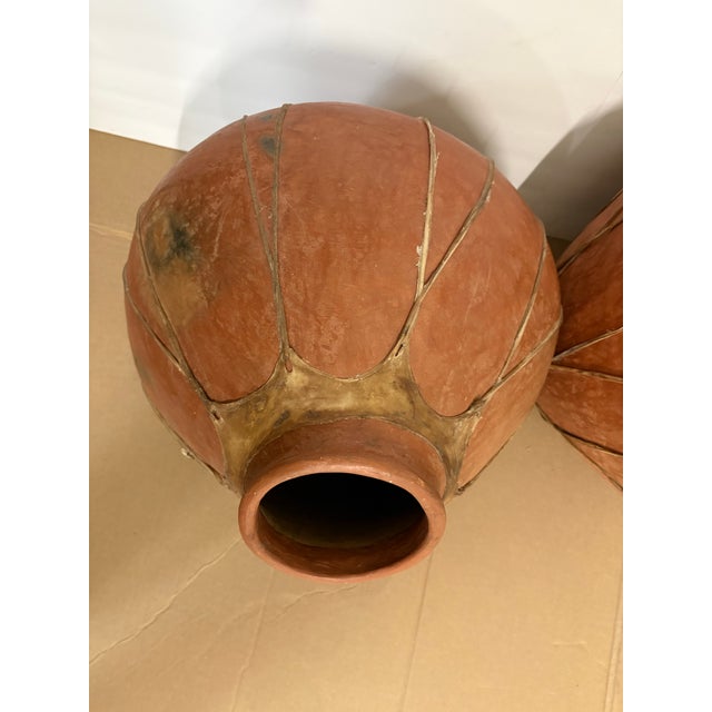 Elevate your interior with a striking, large-scale pair of authentic mid-20th-century Tarahumara (Rarámuri) rawhide-bound...