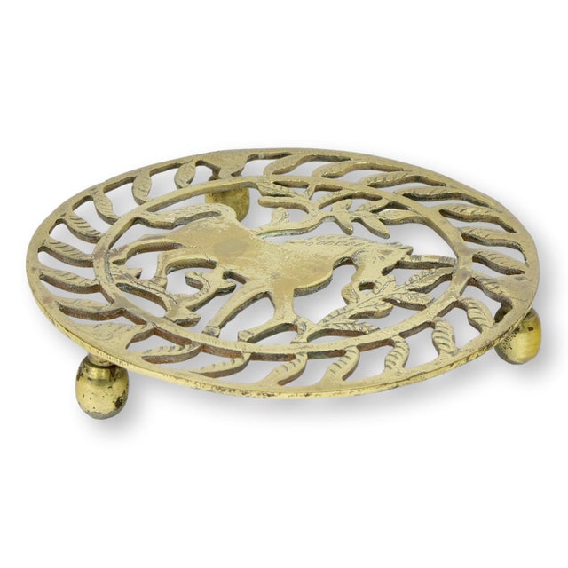 Late 19th century English brass trivet featuring a horse beneath a stylized tree within an openwork circular frame. Raised...