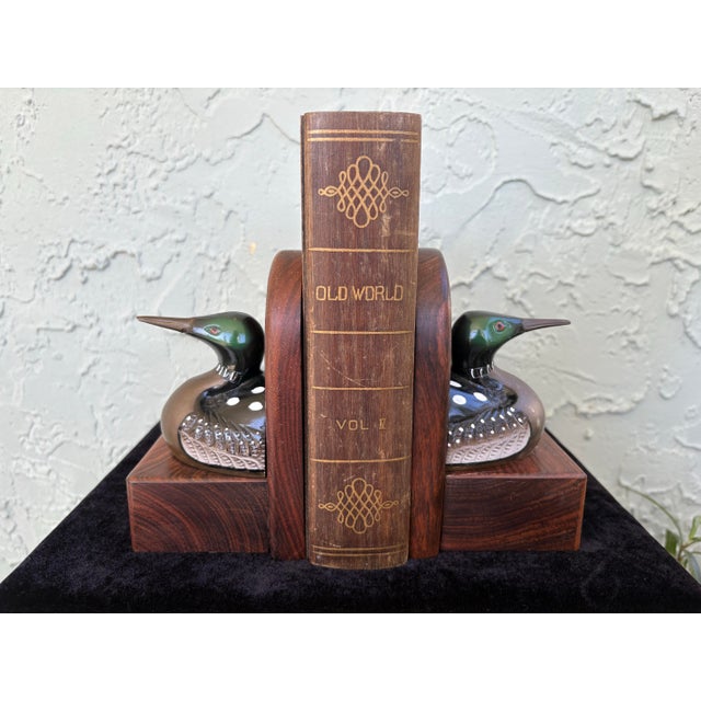 A striking vintage pair of loon bird bookends featuring hand-painted metal (likely brass) loons mounted on solid hardwood...