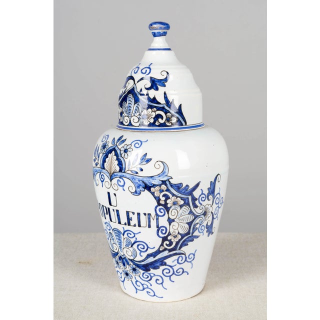 A delft faience apothecary jar, or pharmacy pot, with domed lid, blue hand painted decoration and label: U Populeum....