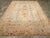 An antique Turkish Oushak room size carpet. The ivory field centers a beige four armed medallion with stylized pendants...