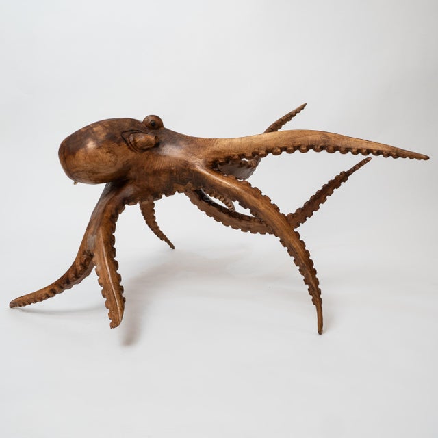 A striking monumental hand-carved octopus sculpture, crafted from a single solid piece of wood, likely suar wood from...