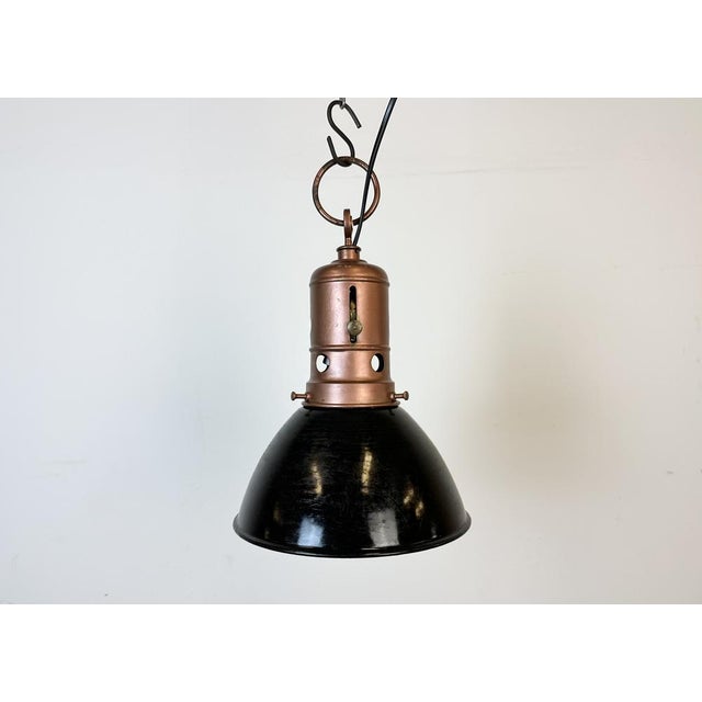 Industrial black enamel factory pendant light made in Italy during the 1950s. White enamel inside the shade. Iron top in...