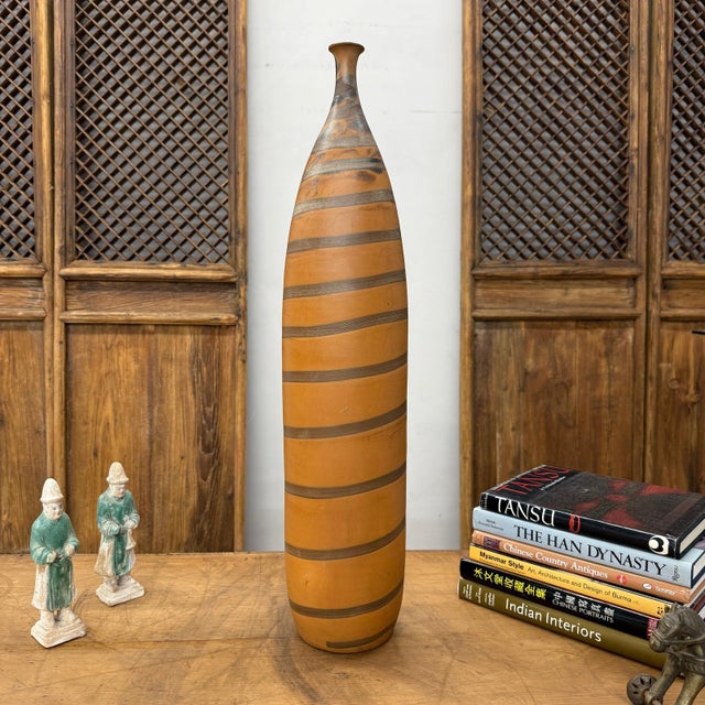 "About This Piece About This Piece Commanding in height and graceful in form, this vase brings together earthy warmth and...