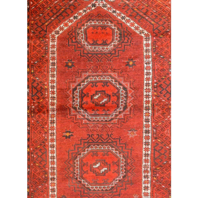A charming early 20th century Afghan Ersari Prayer Rug with three octagonal medallions on a crimson background with...