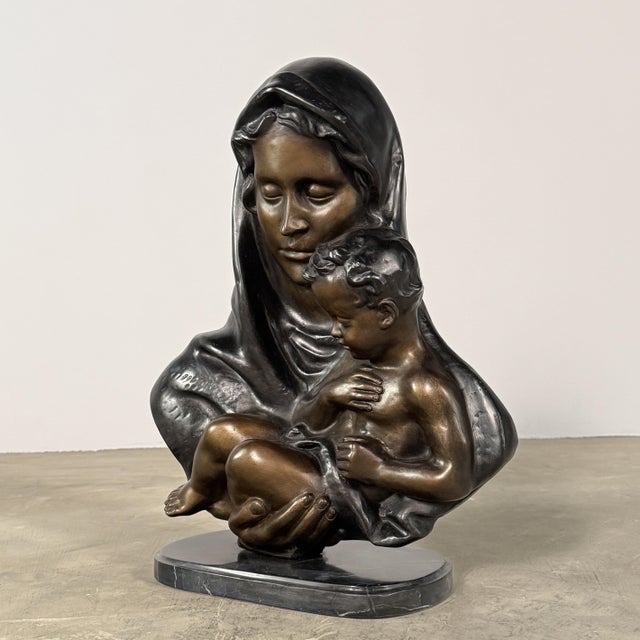 A beautifully modeled bronze Madonna and Child relief sculpture, capturing the intimacy between the Virgin Mary and the...