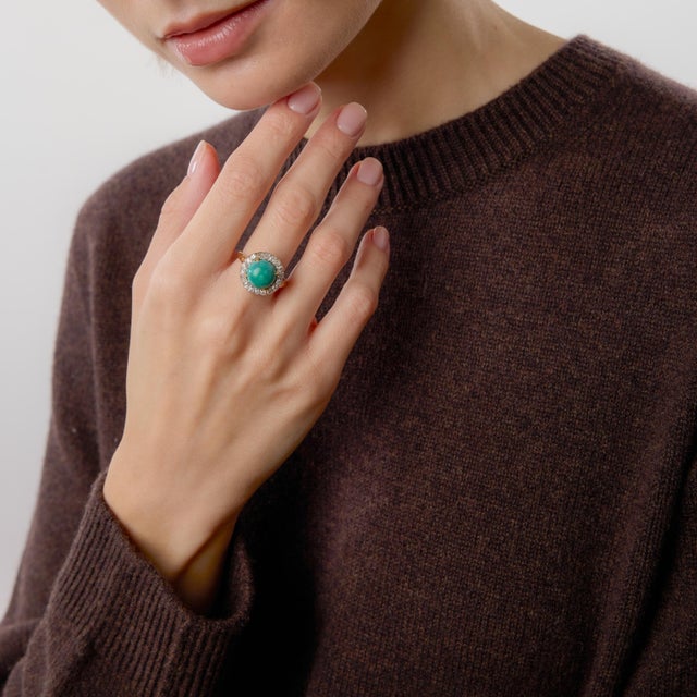 This Edwardian turquoise and diamond cluster ring is a captivating example of early twentieth-century elegance and...