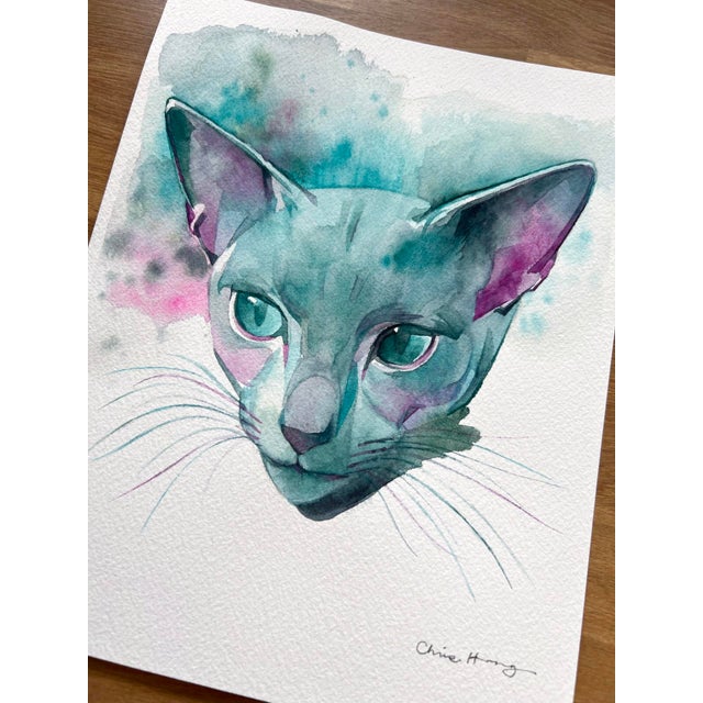 Steely Sweetheart captures the essence of a sleek cat's face, rendered in a delicate interplay of watercolors that blend...