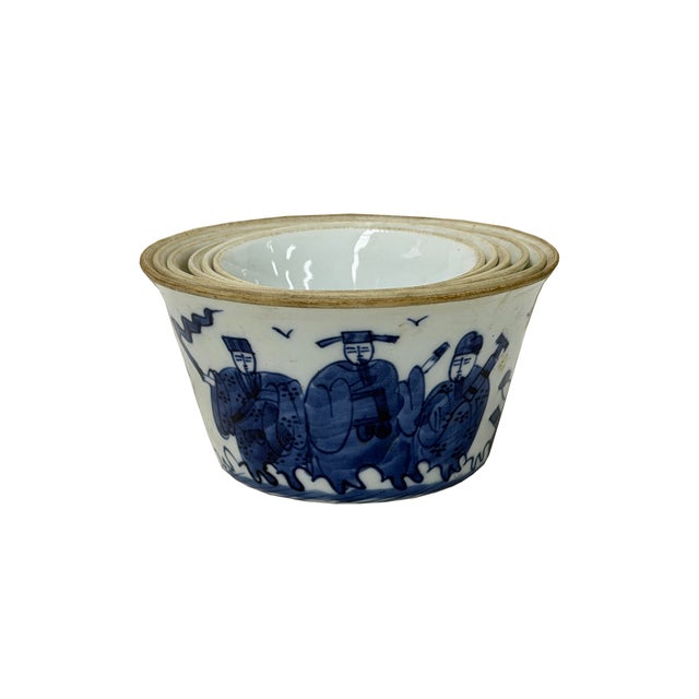 This charming nesting set consists of multiple porcelain bowls featuring a classic white interior and contrasting blue-...