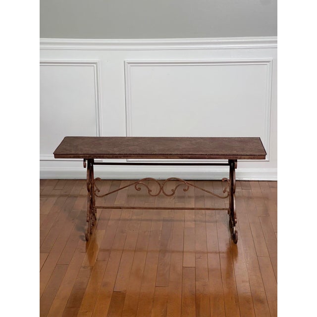 Wrought iron sculptural scroll base bench or coffee table with a faux leathered trompe-l'oeil finish metal top, 1960s....