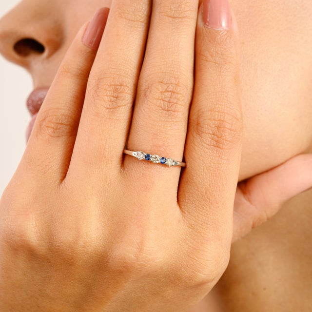 A timeless blend of grace and sparkle, this elegant band features vibrant blue sapphires (0.06 ct) alternating with...