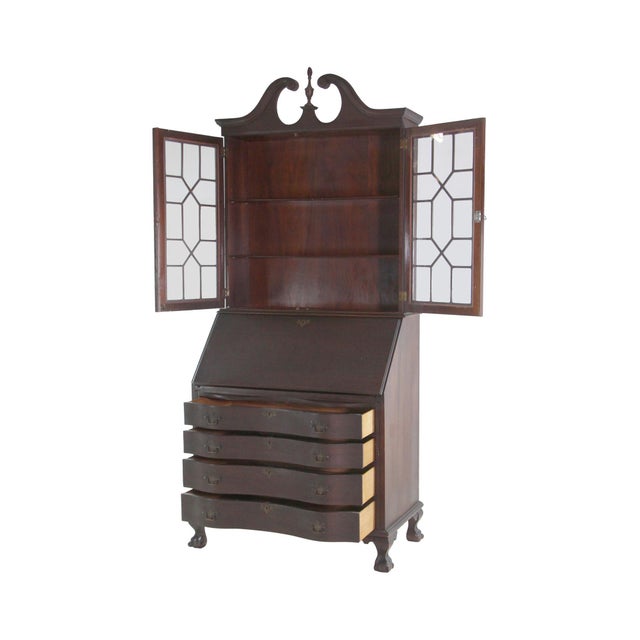 Antique mahogany secretary desk with Chippendale styling. Four serpentine fronted drawers support a hinged writing bureau...