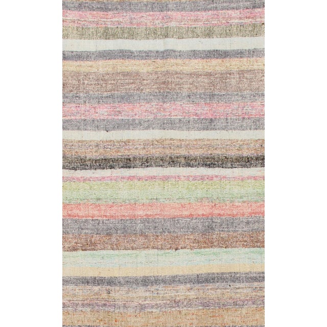 This vintage Turkish Kilim long runner, handwoven in the 1960s, showcases the simplicity and boldness characteristic of...