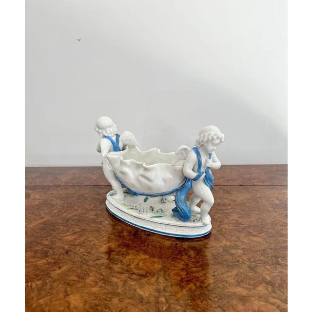 Antique Victorian quality continental porcelain group having two cherubs carrying a shaped dish standing on an oval shaped...