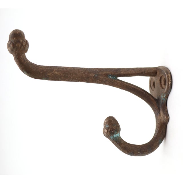 Antique brass double arm acorn wall hook with a dark finish. The original mounting screws are not available. Good...