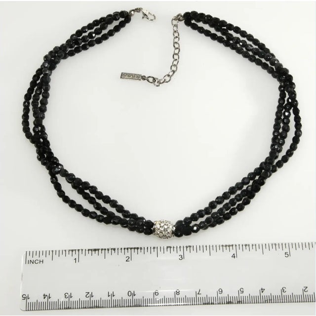 Vintage necklace in a twisting mini torsade style. It features a sparkling clear rhinestone barrel shaped element as the...