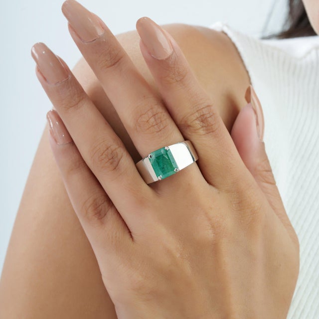 The Contemporary Wide-Band Octagon-Cut Green Emerald Statement Signet Ring features a striking 2.74 carat emerald in a...