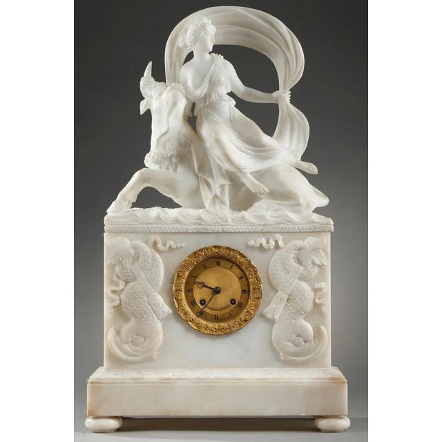 Rare alabaster clock representing "The abduction of Europa" by Zeus metamorphosed into a bull. Europa, dressed in an...