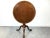 A round mahogany tilt-top table with an inset tooled leather top, tapered pedestal, cabriole legs and elongated pad feet....
