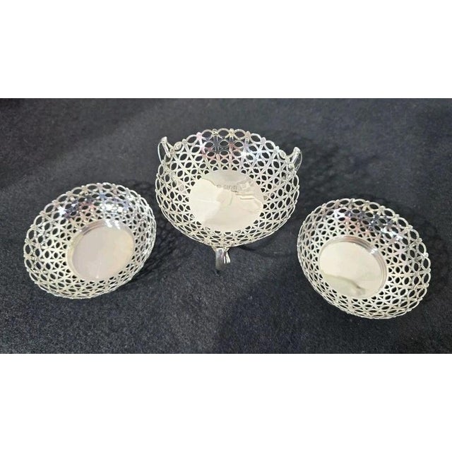 A fine Edwardian sterling silver three-piece table centre ensemble comprising a central bon bon tazza accompanied by two...
