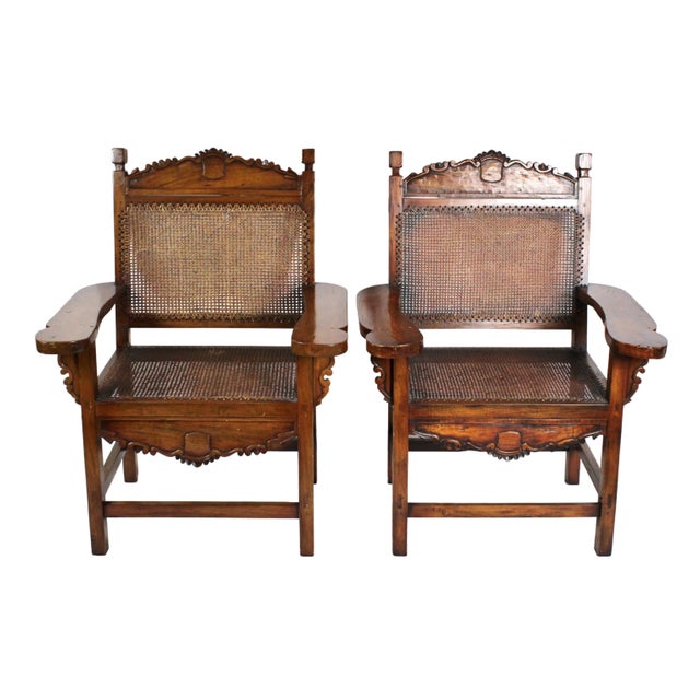 Striking pair of hand crafted caned armchairs. Anglo Indian hand carved chairs, with decorative touches on the top of the...