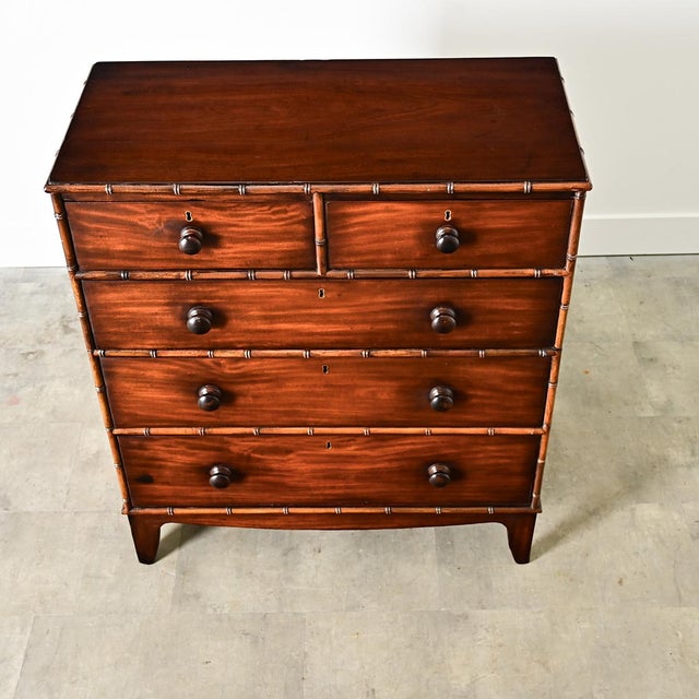 An English 19th century campaign chest in the Regency taste with faux bamboo carving on the trim for an exotic touch as if...