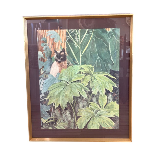 Large framed Gene Pelham “Siamese Cat in the Garden” art print featuring a striking blue-eyed Siamese cat nestled among...