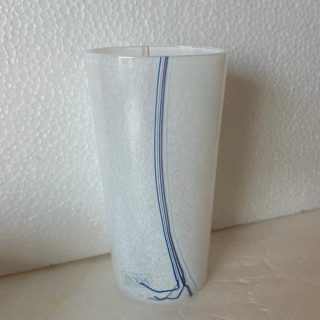 Hand made Kosta Boda translucent vase with white, blue, orange and tan stripes. It maintains its original sticker and is...