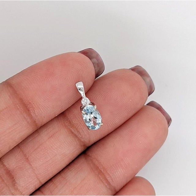 This beautiful pendant features a 0.4 carat oval aquamarine gemstone with a natural earth mined diamond set in solid 14K...