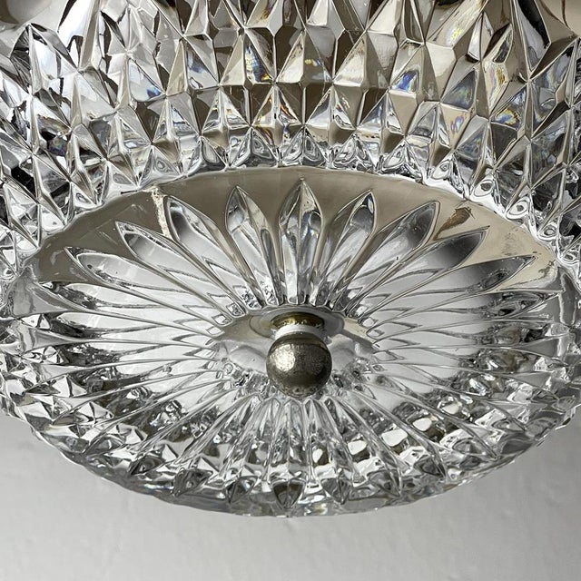 Superb mid-century chandelier made in italy in the 1960s. thick glass decorated with an ornament is framed by a metal...